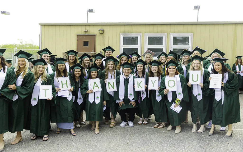 Hagerstown Community College graduates holding signs that spell "Thank you."